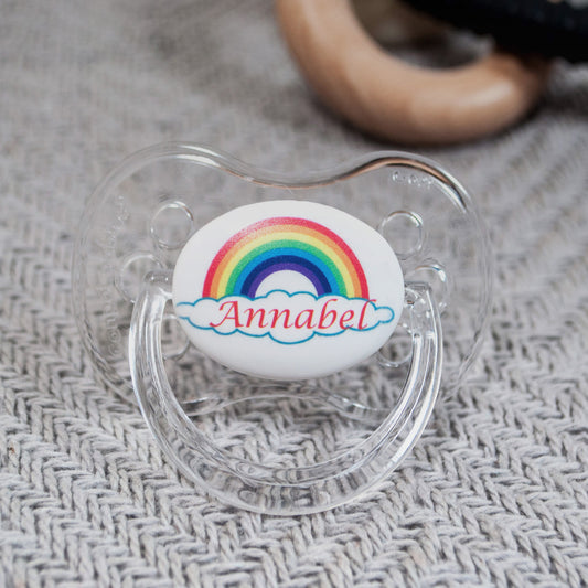 personalised baby dummy with rainbow design and name.