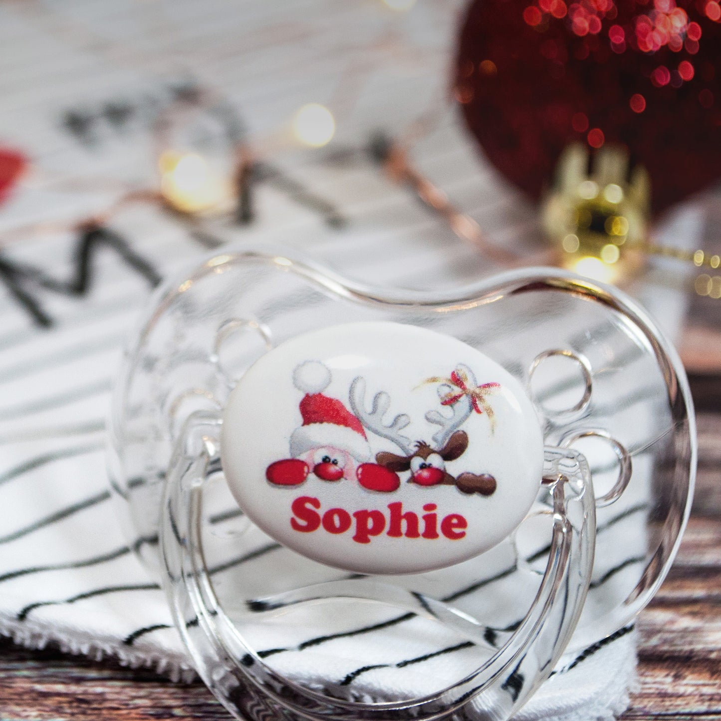 Personalised baby dummy with image of santa and baby name.