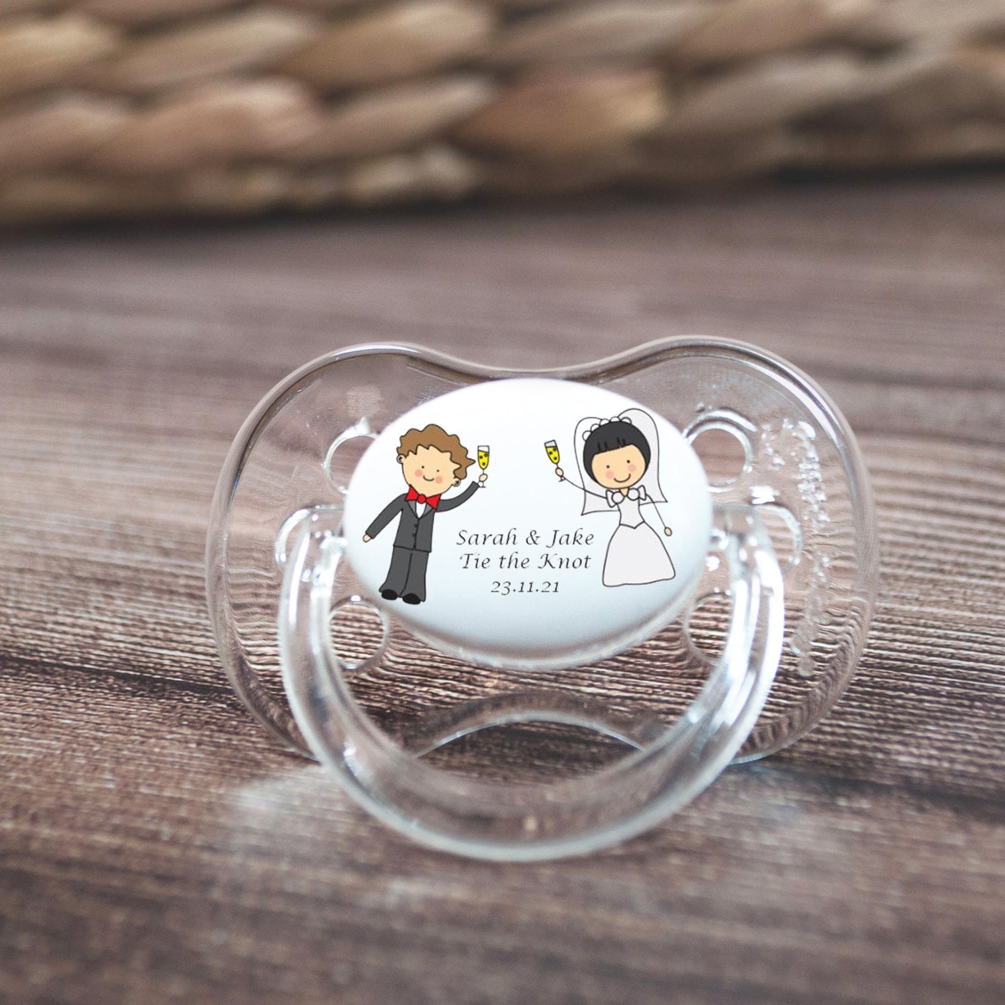 Personalised baby dummy with bride and groom personalised with wedding details.