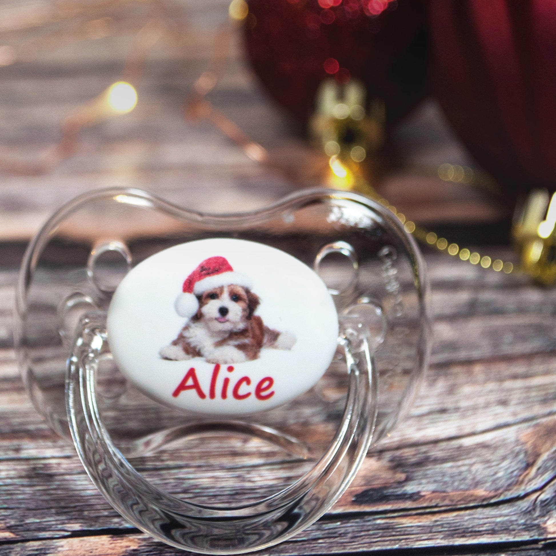 Personalised baby dummy with cute puppy wearing christmas hat.